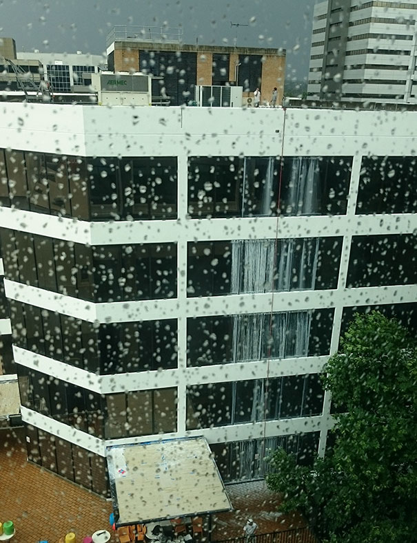 Building with window cleaning failure, water streaks visible on glass, highlighting a job not done properly.