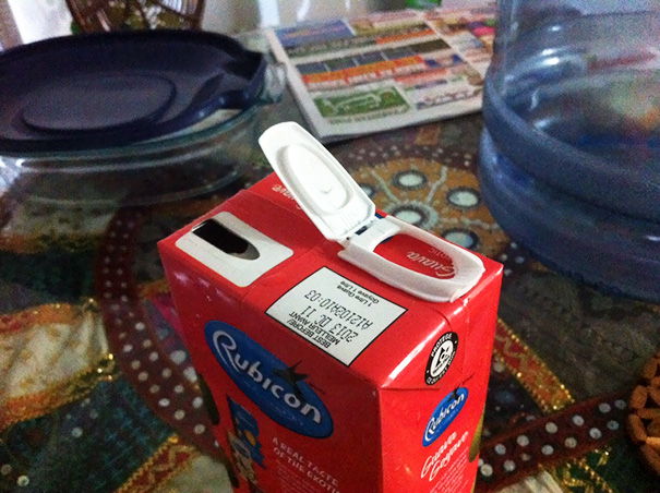 Juice carton with mismatched spout and lid placement, illustrating job failure.