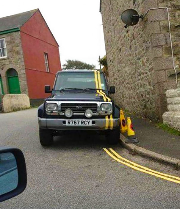 Car with a misaligned yellow road line painted over it, illustrating a funny failed job.