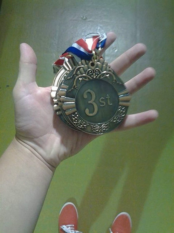 Medal reading "3st" in a hand, showcasing a failed job e*******n.