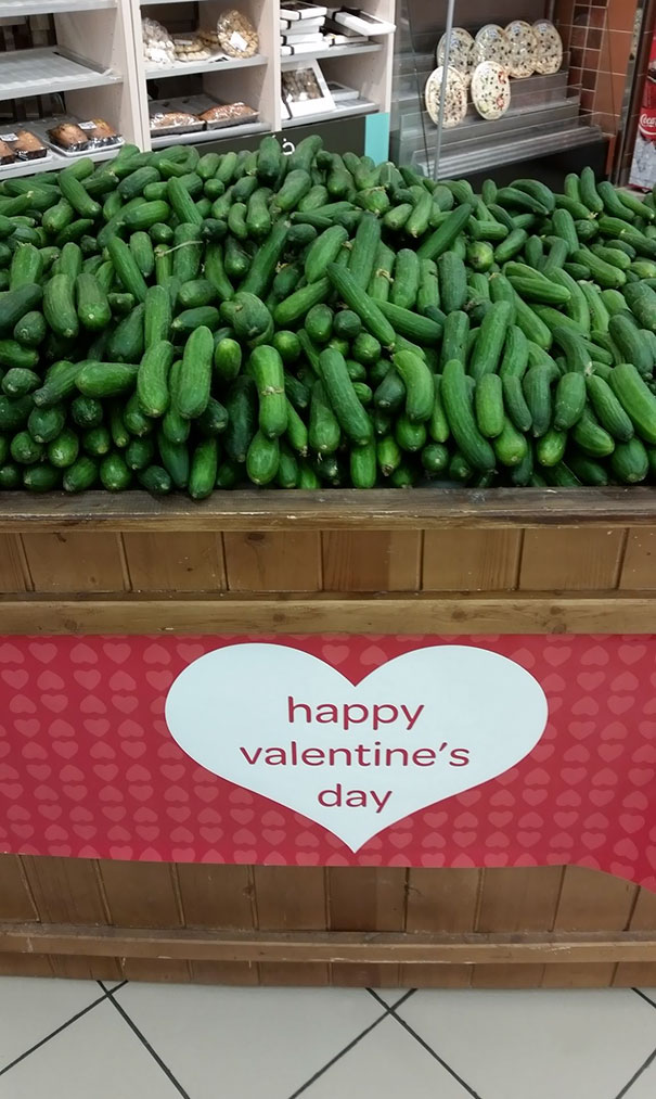 Store display of cucumbers with a Valentine's Day sign, highlighting a job fail.