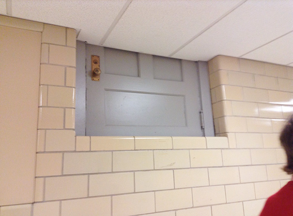 A misplaced door high up on a tiled wall, illustrating a job fail.
