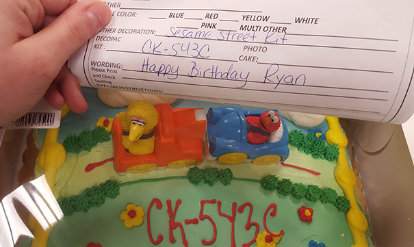 Cake with Sesame Street theme but incorrectly decorated with "CK-543C" on top.
