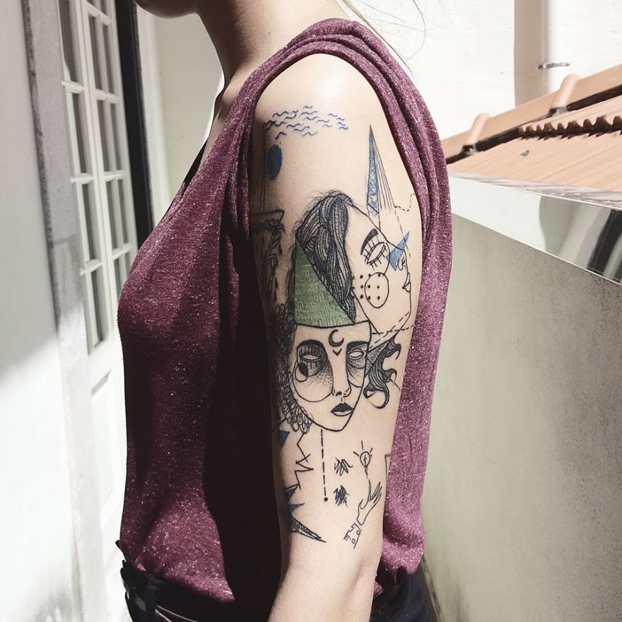 Person with colorful, sketchy tattoos on arm, standing outdoors in sunlight.