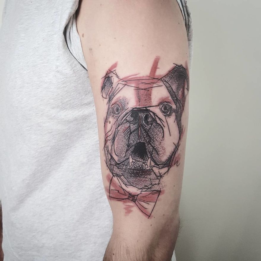 Sketchy tattoo of a bulldog on an arm, featuring colorful accents and abstract lines.