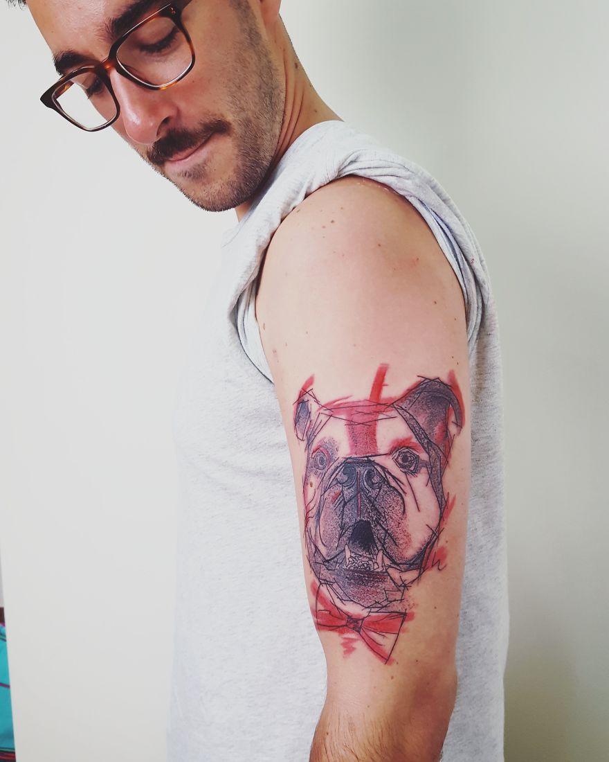 Man with a colorful, sketchy tattoo of a bulldog on his upper arm.