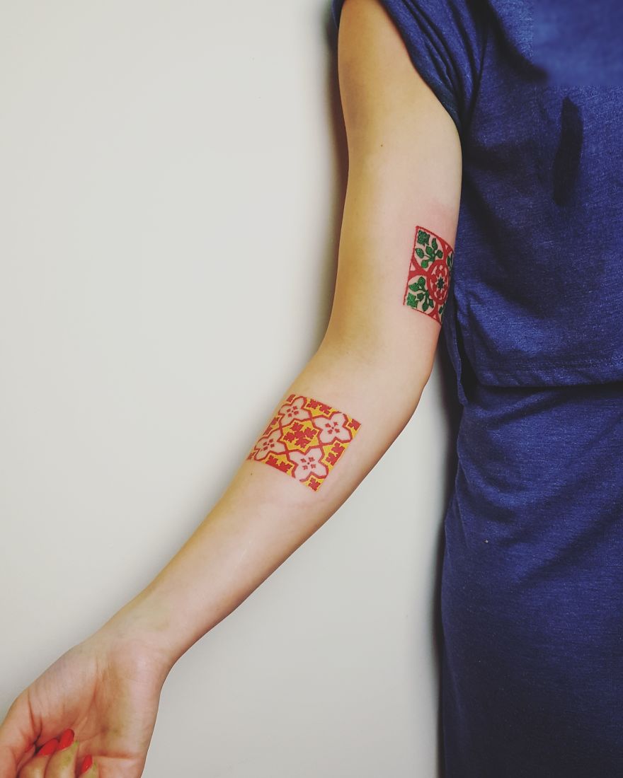 Colorful sketchy tattoos on a person's arm featuring geometric patterns in red and green with artistic design.