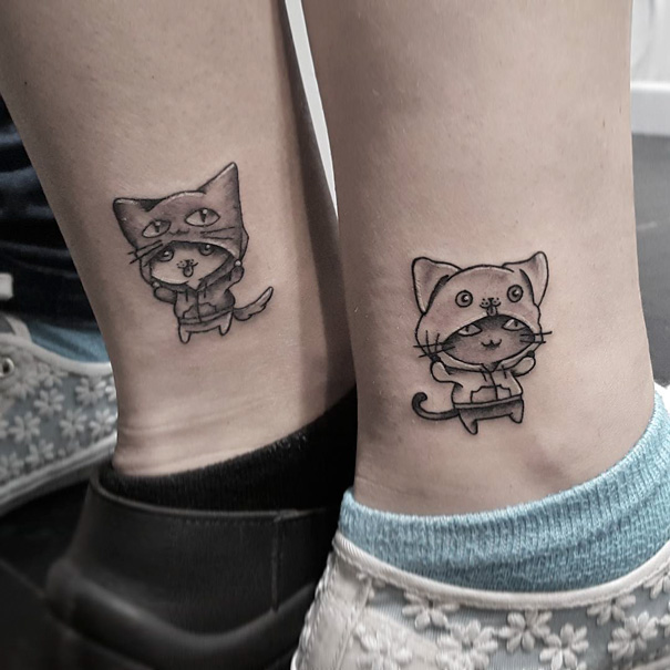 Trio tattoos on ankles featuring cute cartoon cats, showcasing playful designs in a matching style.