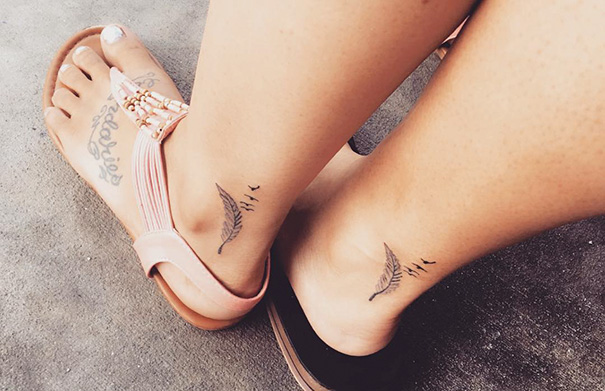 Matching trio tattoos with birds and leaves on ankles, two women in sandals.
