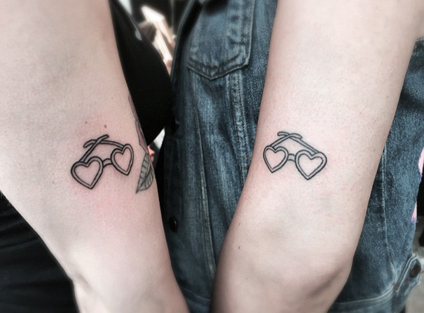 Heart-shaped glasses trio tattoos on arms, showcasing creative tattoo ideas for groups.