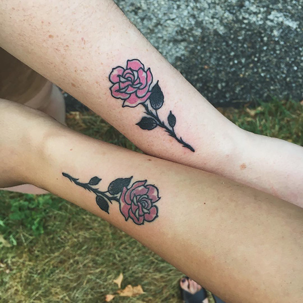 Trio tattoos of pink roses on two forearms, showcasing matching floral designs.