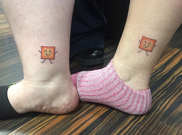 Two ankles with matching smiling cartoon square tattoos, showcasing trio tattoo ideas.