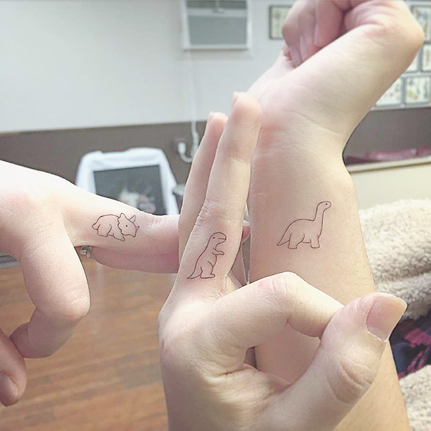 Three wrists with minimalist dinosaur trio tattoos, each with a different dinosaur design.