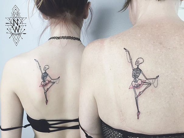 Two people with matching skeleton ballerina trio tattoos on their upper backs.