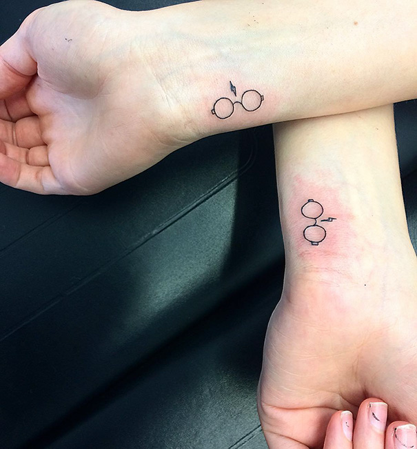 Simple trio tattoos featuring minimalist designs of round glasses and a lightning bolt on wrists.