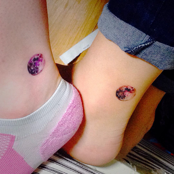 Matching trio tattoos of colorful moons on two ankles, symbolizing unity and creativity.