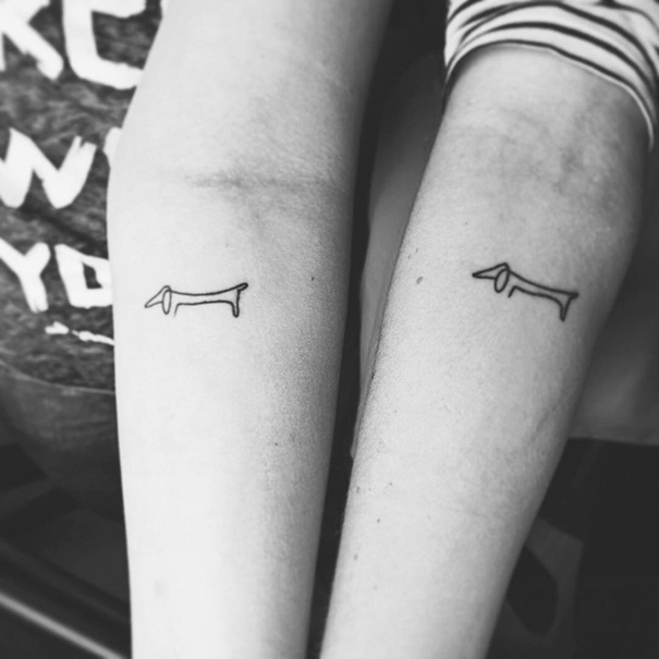 Minimalist dog tattoos on two forearms, showcasing creative trio tattoo ideas in simple line art style.
