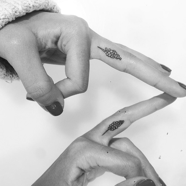 Three minimalist tattoos on fingers, featuring small geometric designs. Perfect trio tattoo inspiration.