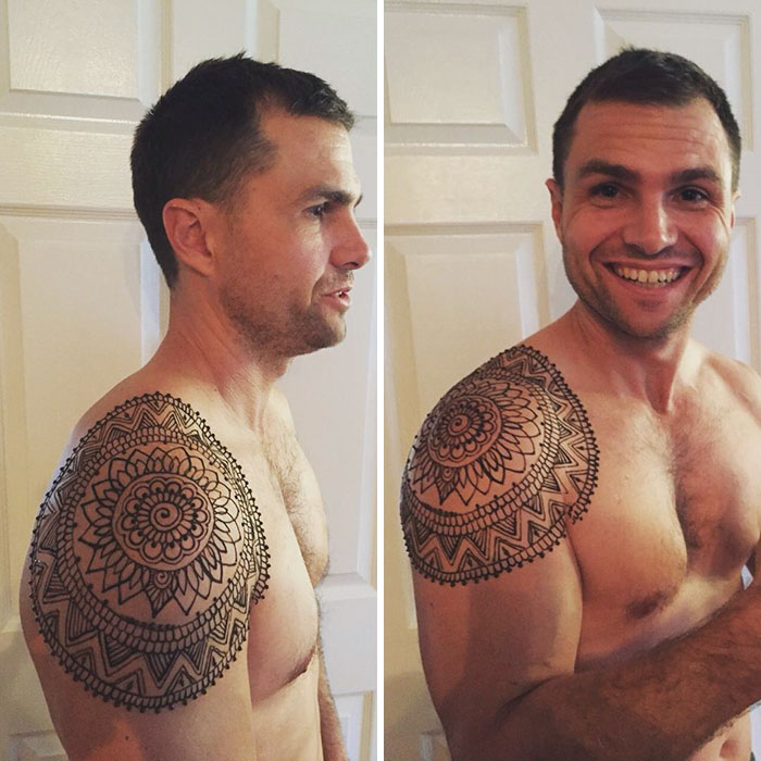 Man displaying intricate henna tattoo on shoulder, part of the 'Menna' trend.