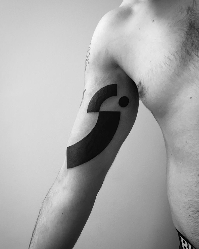Minimalist digitally-designed tattoo inked on a person's upper arm, featuring bold geometric shapes.