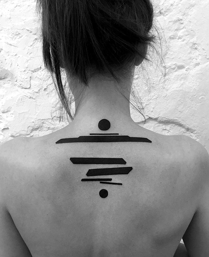 Minimalist digitally-designed tattoo on a person's upper back, featuring geometric shapes by a Russian artist.