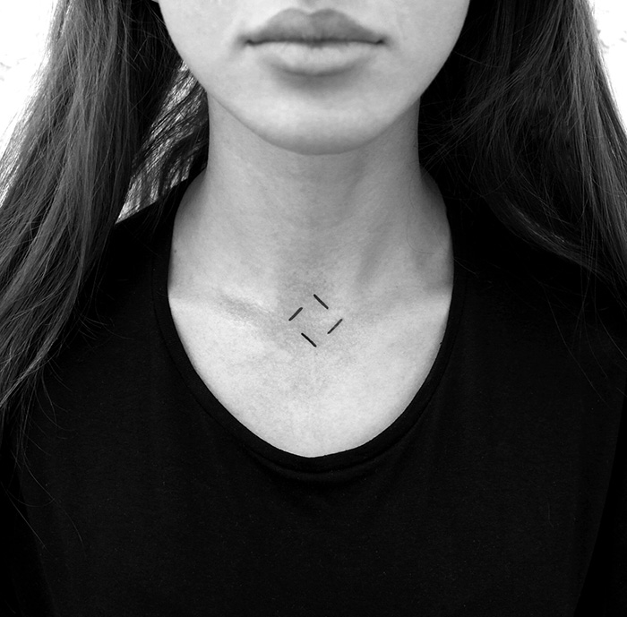 Minimalist digitally-designed tattoo on a person's upper chest, featuring simple geometric lines.