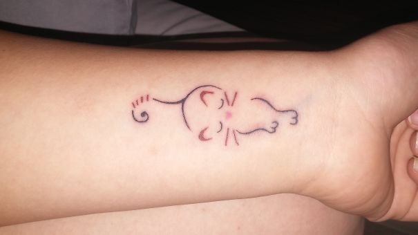 Minimalistic cat tattoo on forearm, showcasing a peaceful feline design for cat lovers.