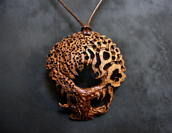 Intricate pendant resembling a skull with a textured, irregular pattern, highlighting the beauty of imperfection.