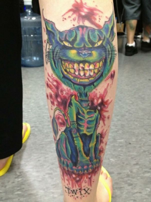 Colorful Cheshire cat tattoo on leg, showcasing a vibrant expression of a cat person.