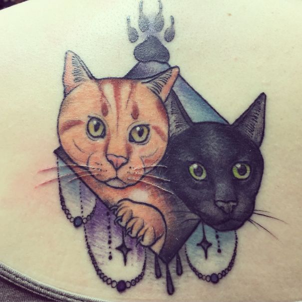 Colorful tattoo featuring two cats with geometric patterns and decorative elements, perfect for cat person expression.
