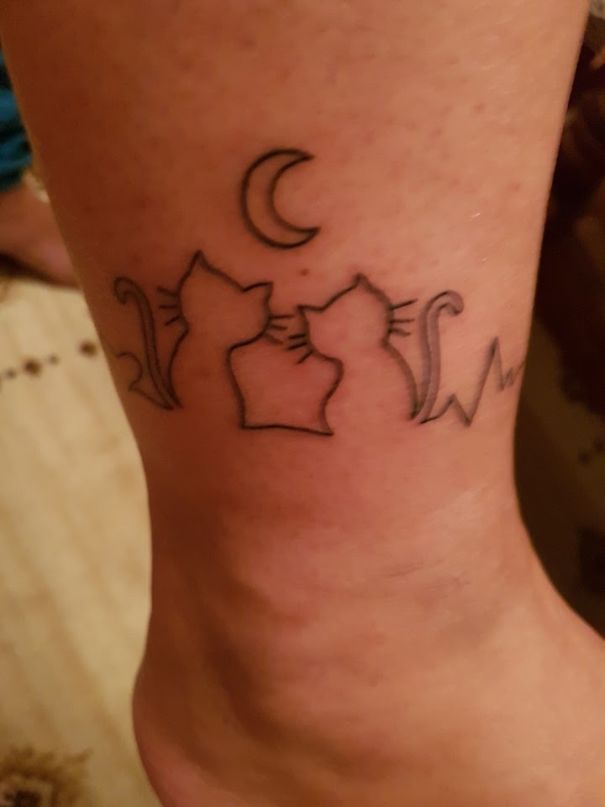 Minimalist cat tattoo featuring three cat silhouettes under a crescent moon.