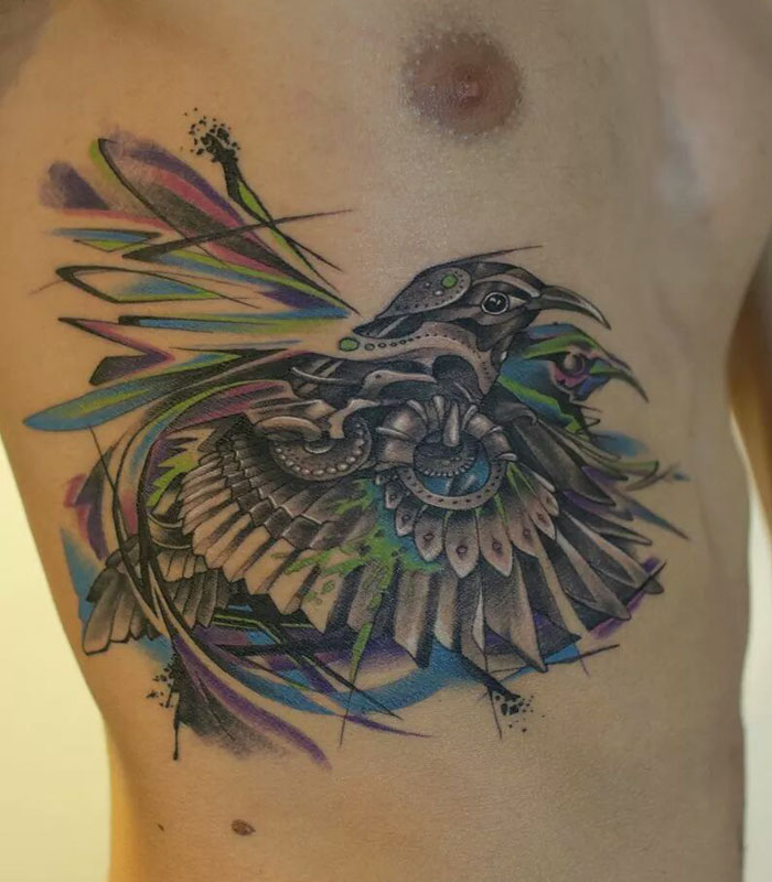 Colorful small bird tattoo on ribcage, showcasing intricate design and unique style.