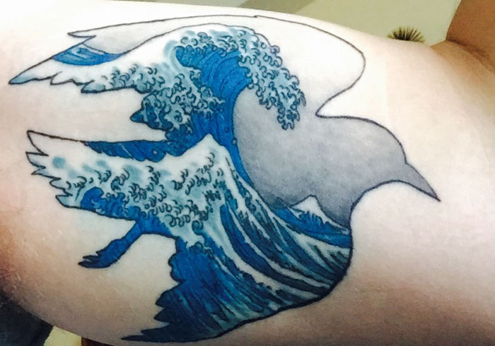 Small bird tattoo featuring a wave design, combining natural elements with artistic ink inspiration.