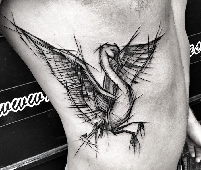 Unique small bird tattoo with sketch-style lines on a person's side.