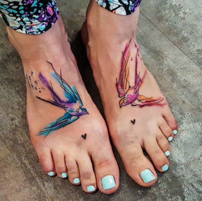 Colorful small bird tattoos on feet, showcasing unique inkspired artistry.