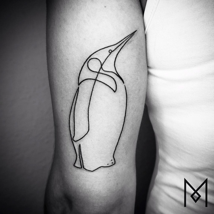 Minimalist small bird tattoo design on an arm, featuring elegant line work.