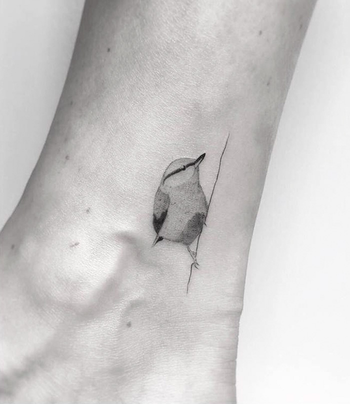 Small bird tattoo on ankle, minimalist ink design for inspiration.