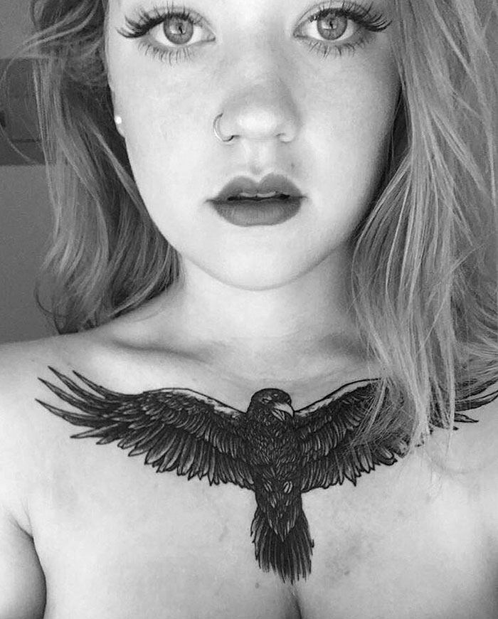 Woman with detailed small bird tattoo on chest, showcasing artistic inspiration for unique tattoo designs.