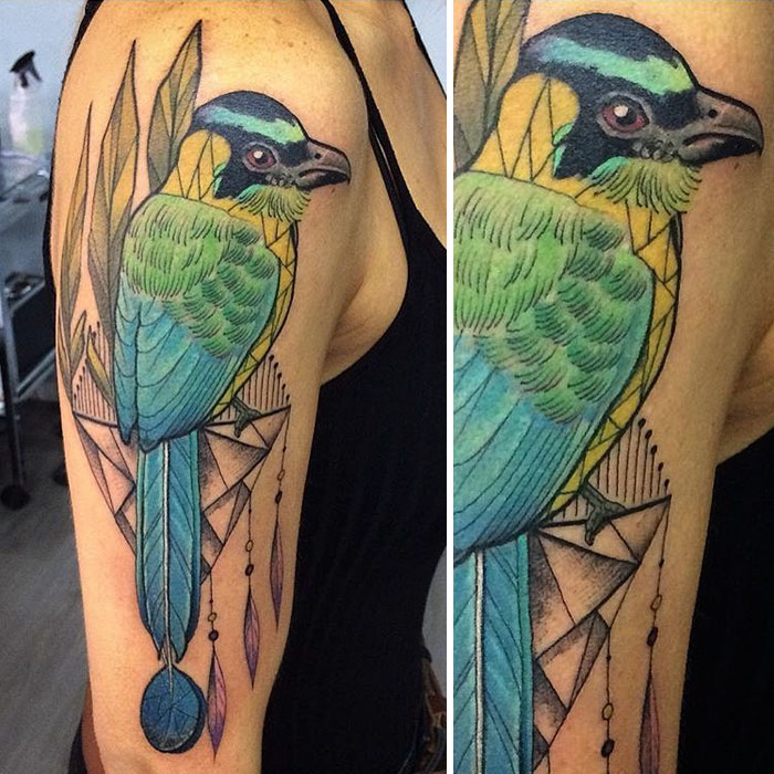 Colorful small bird tattoo with geometric accents on upper arm.