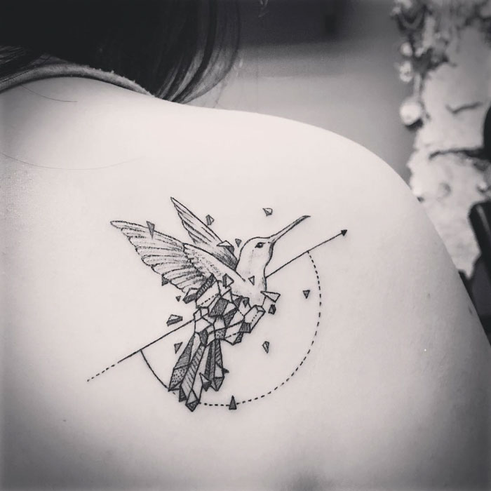Geometric small bird tattoo on shoulder, featuring intricate details and clean lines, showcasing unique inkspiration.