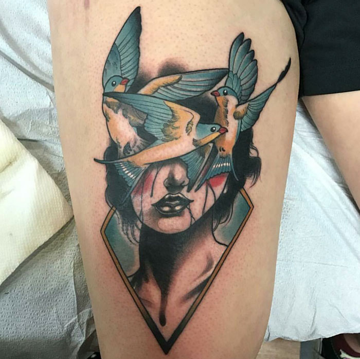 Unique small bird tattoo with colorful swallows and geometric design on a person's arm.