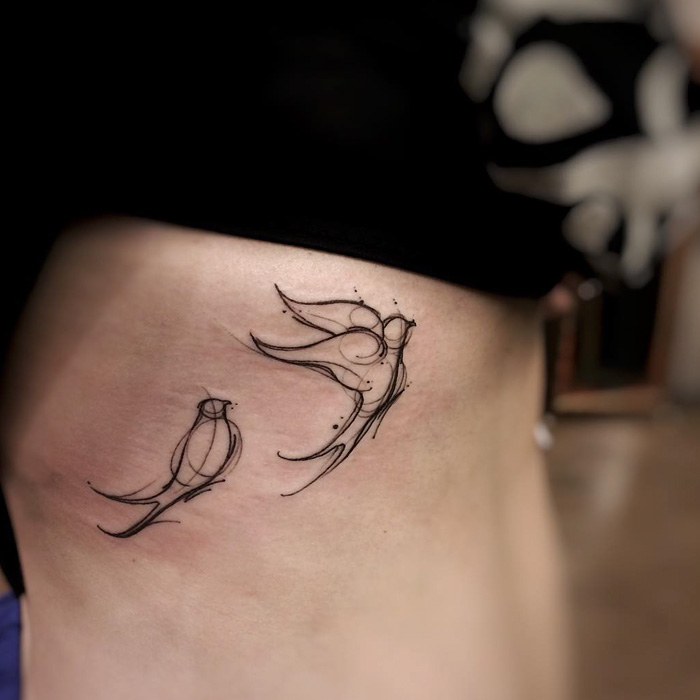 Minimalist small bird tattoos on skin, showcasing unique line art design.