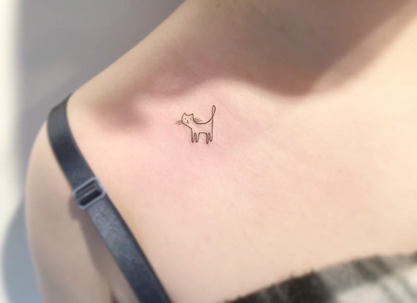 Minimalist cat tattoo on shoulder, perfect for expressing your love as a cat person.
