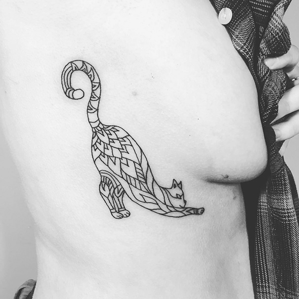 Geometric cat tattoo on a person's side, showcasing intricate line designs and unique cat art style.