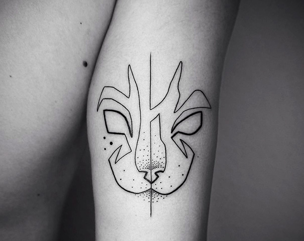 Abstract cat tattoo design on arm, showcasing minimalistic line art for cat enthusiasts.