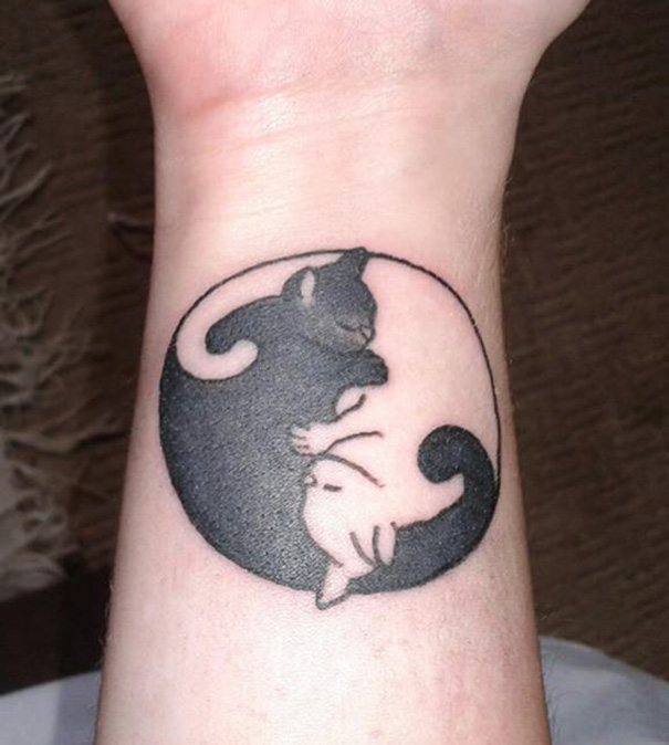 Yin yang cat tattoo design on a wrist, showcasing stylish expression for cat lovers.