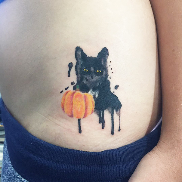Cat tattoo featuring a black feline with a pumpkin, showcasing unique and creative ink for cat lovers.