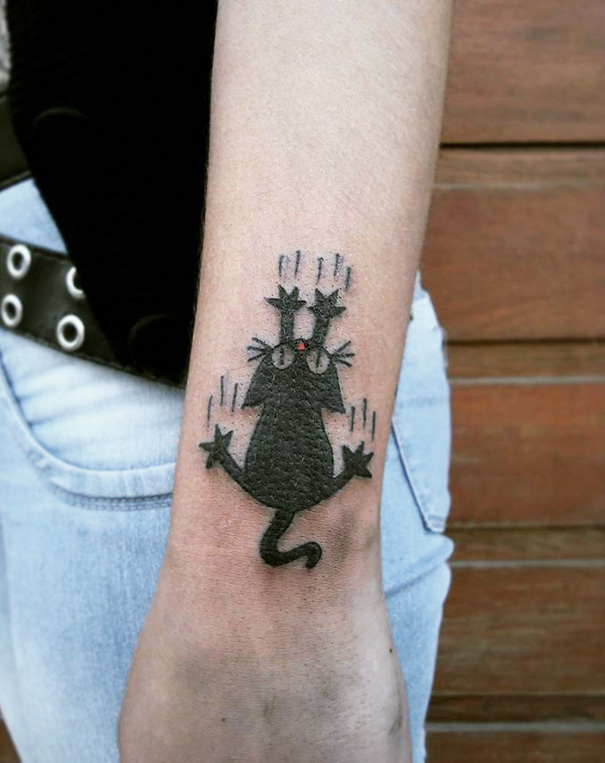 Black cat tattoo on forearm showcasing a playful and expressive design for cat lovers.