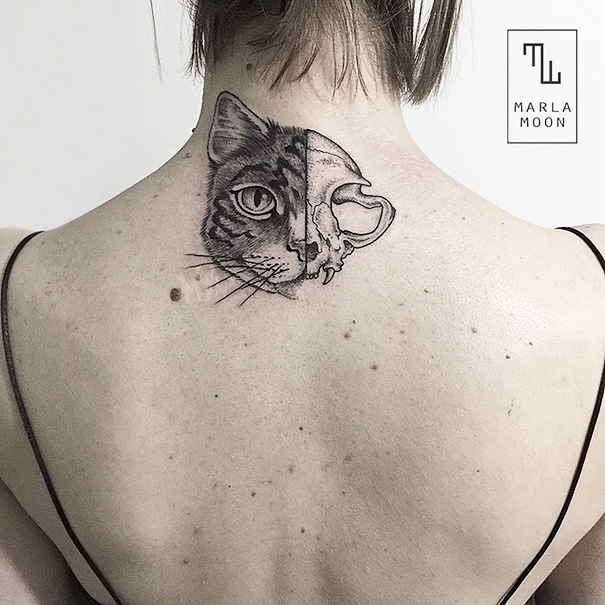 Back tattoo featuring a cat design with half face and half skull.