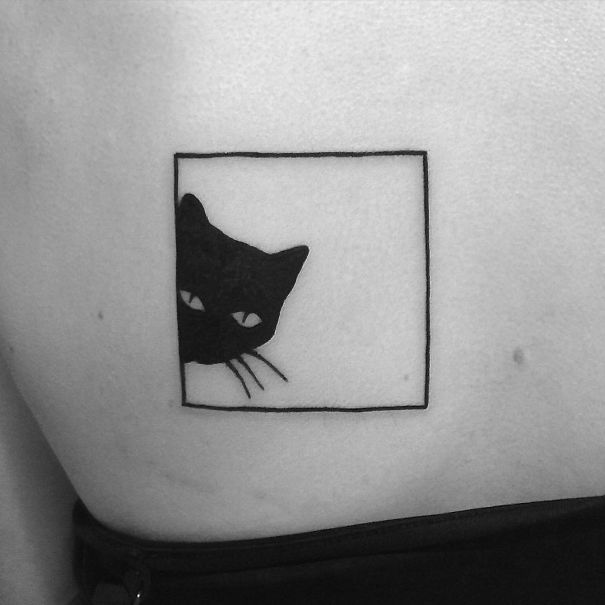 Minimalist cat tattoo featuring a black cat peeking from a square outline.